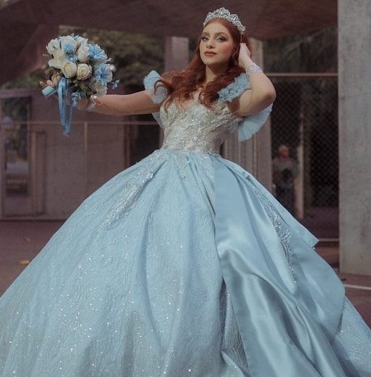 Woman in a blue ballgown holding a bouquet