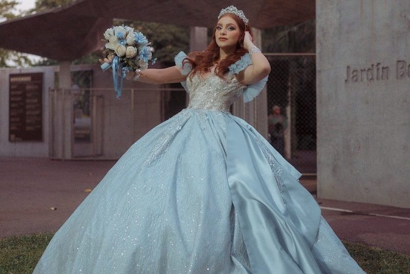 Woman in a blue ballgown holding a bouquet