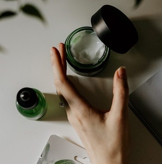 person touching black plastic bottle