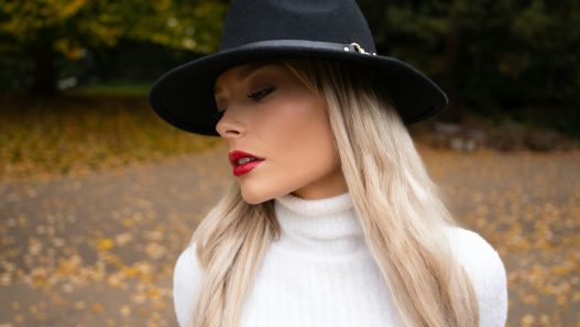 Woman wearing a black fedora and white turtleneck