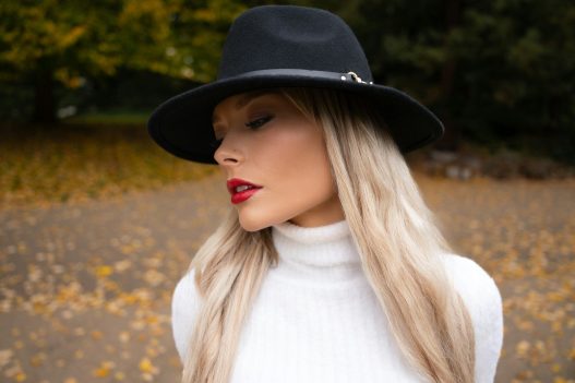 Woman wearing a black fedora and white turtleneck