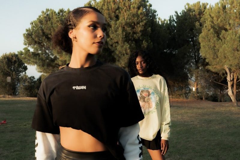 Two women posing in a grassy outdoor setting.