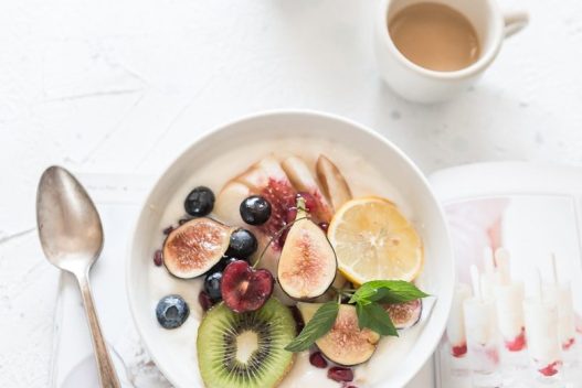 white ceramic plate beside gray steel spoon