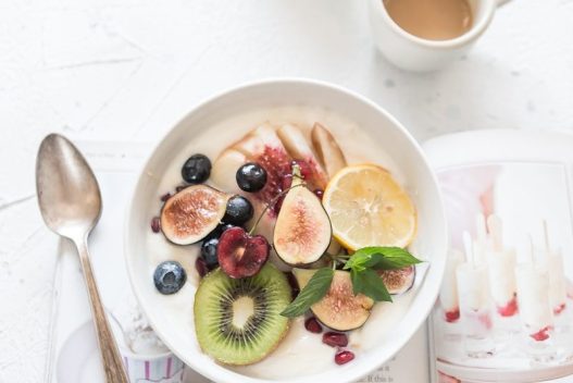 white ceramic plate beside gray steel spoon