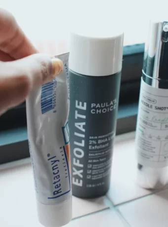 Skin Cycling ile düzenli cilt bakım rutini Gece cilt bakım rutini uygulayan bir kişi, aynanın karşısında cildine bakım yaparken serum ve nemlendirici kullanıyor.