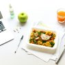 vegetables on plate beside fork and laptop